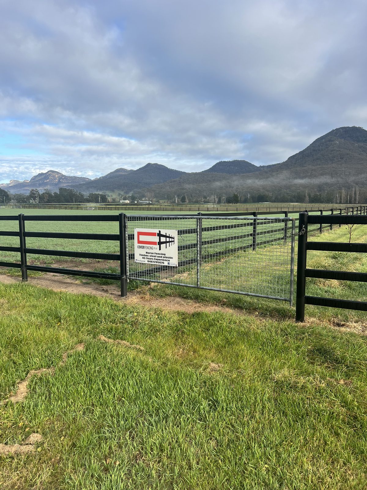 Cover Fencing job sign on site at Widden Stud, with mountains behind