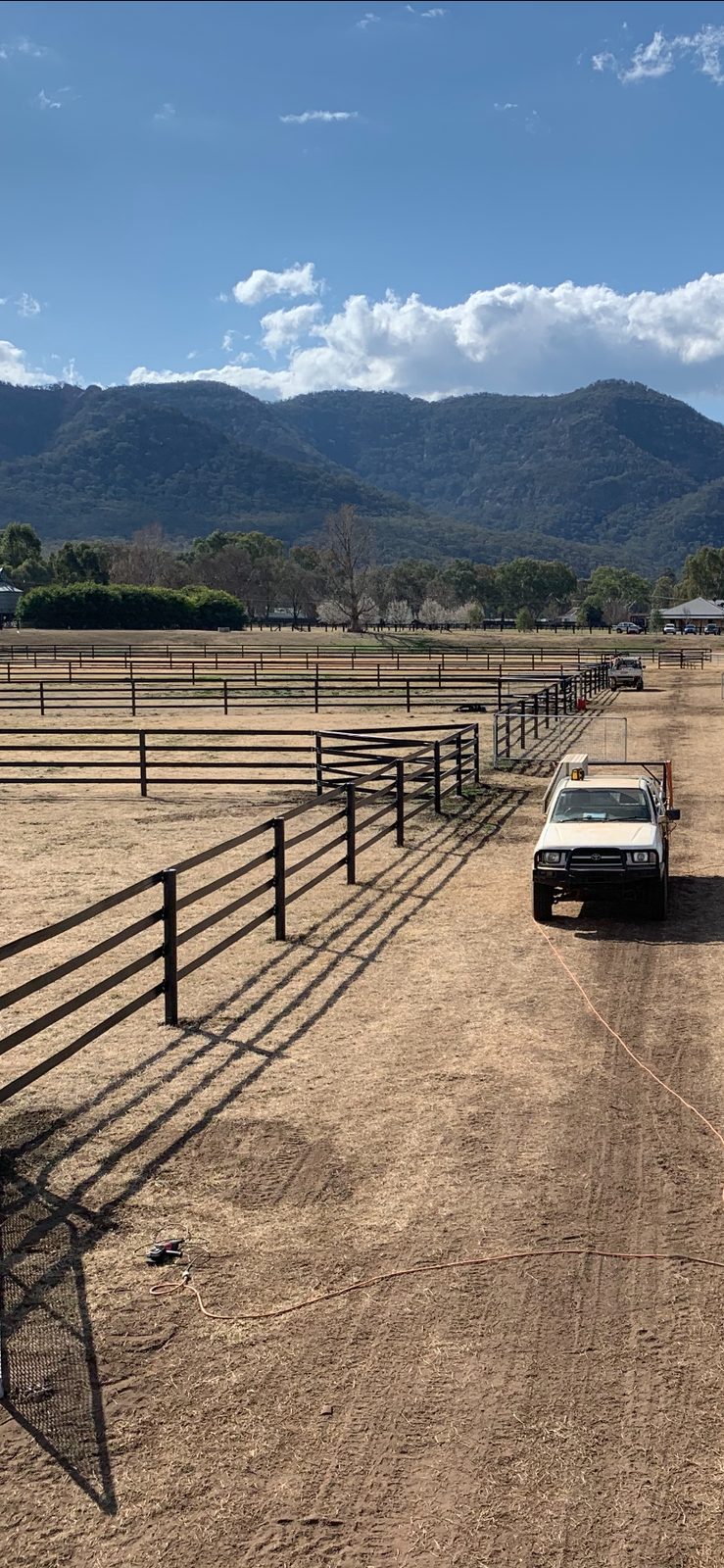Galvanized rail yards at Widden Stud with mountains behind